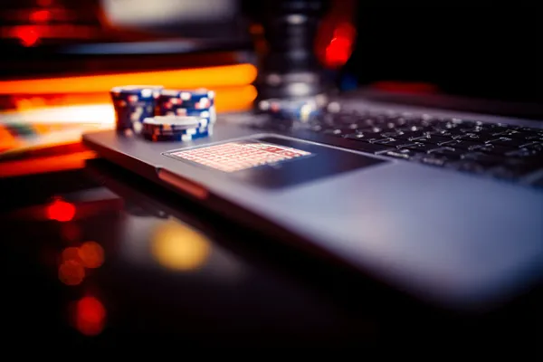 GB44 Games — Explore our rich library of casino classics A woman smiling while playing online games on her laptop, surrounded by neon casino elements, showcasing GB44’s diverse game collection.