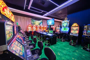 A man celebrating a winning moment on his laptop while gaming symbols float around him, capturing the excitement of GB44 games.