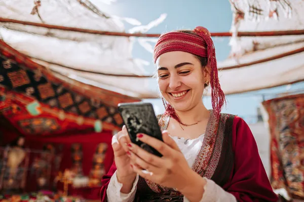 GB44 Mobile Casino — Play anytime, anywhere A player using their smartphone during a festive local event, representing GB44’s fully mobile-friendly casino.